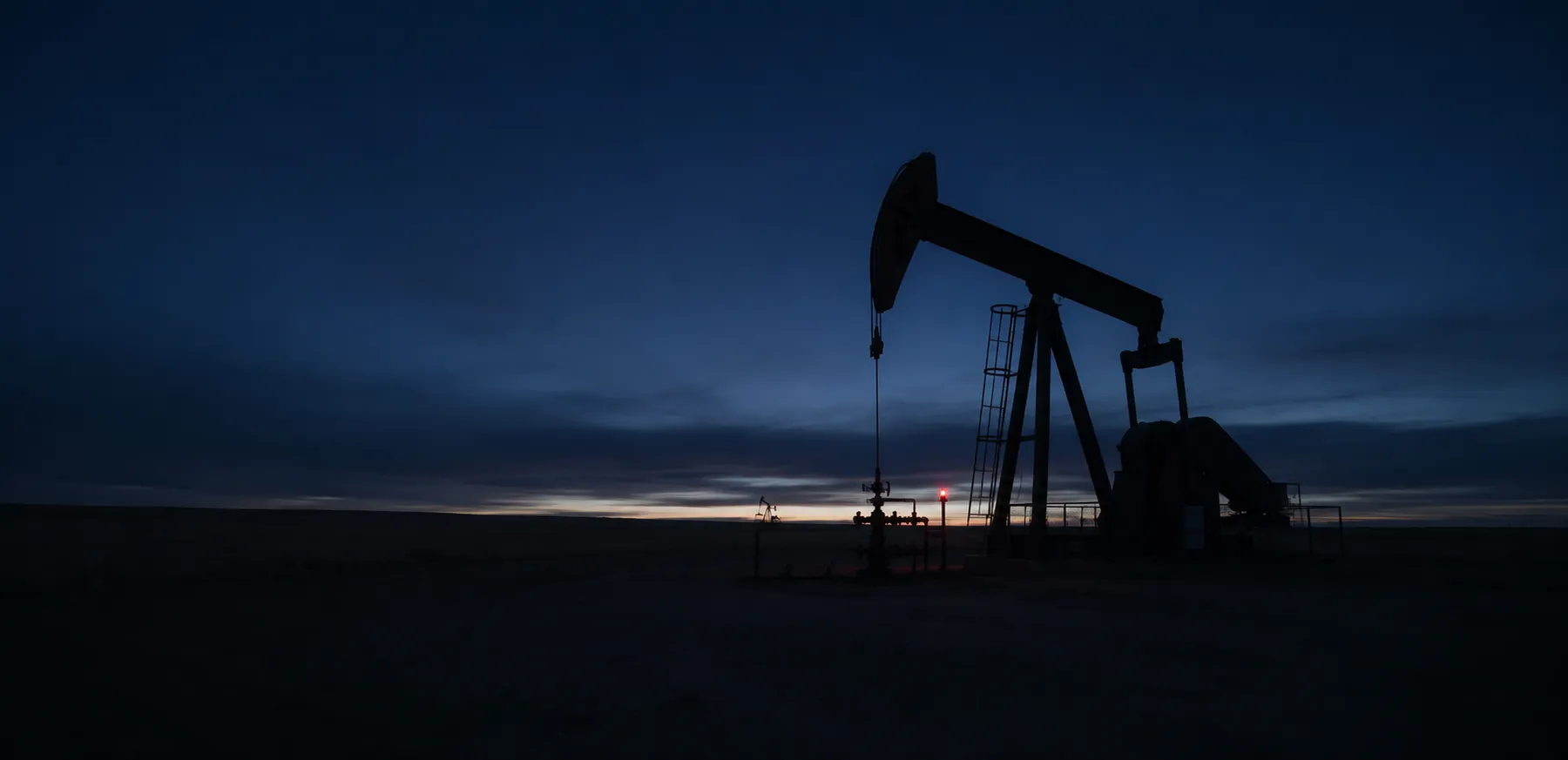 A pumpjack on the prairie at dusk